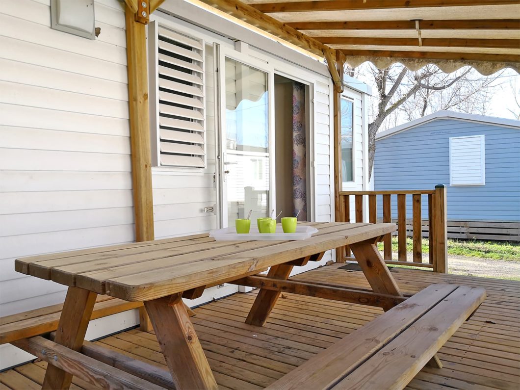 Terrasse couverte d’un mobil home en location au camping Robinson, près de Vias